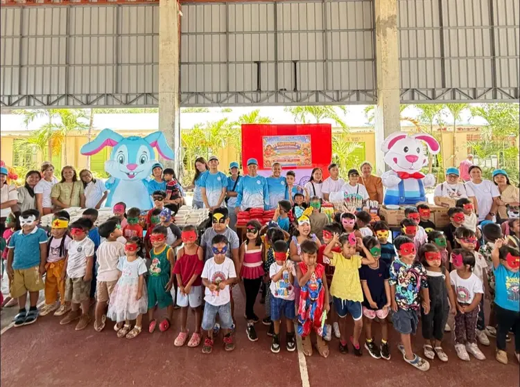 Children and volunteers gathered at a community outreach event decorated with colorful cartoon characters.